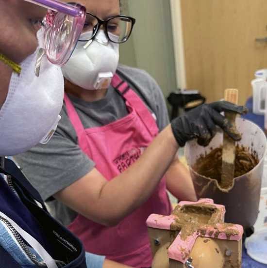 Community casting workshop participant working with mold materials