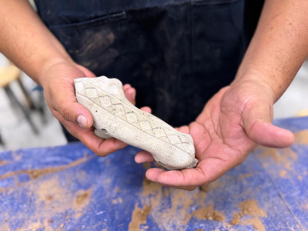 Community member working with mold materials at a bone casting workshop